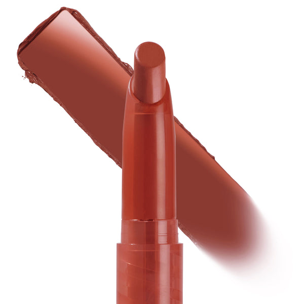 ColourPop Lippie Stix Hot in Here stands upright with the bullet exposed, a warm brick red swatch sweeping behind on a white background, showcasing the creamy, pigmented lip crayon.