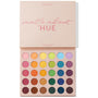 ColourPop Shadow Palette Matte About Hue shown open, displaying 30 all-matte pressed powder shades in a rainbow gradient - pinks, oranges, yellows, greens, blues, purples, and browns - arranged in rows, lid reading “matte about HUE” on a white backdrop.