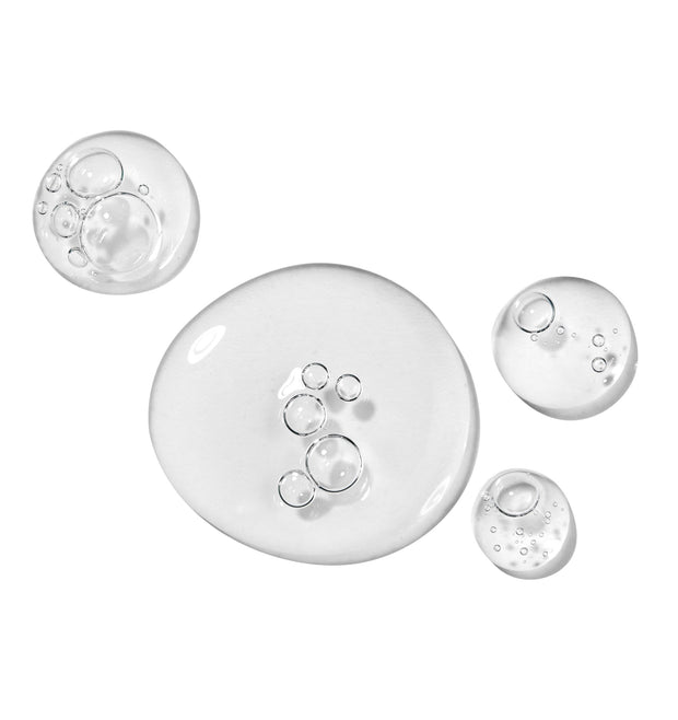 Clear gel serum swatches with suspended microbubbles show the texture of All Clear Purifying Serum, a ColourPop Face Serum, pooling in glossy droplets on a white studio backdrop.