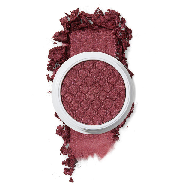 ColourPop Drift Super Shock Shadow featuring a metallic cranberry-burgundy shimmer in a round white pot with honeycomb imprint, crushed pigment smeared in a bold swatch on a white background to show color payoff.