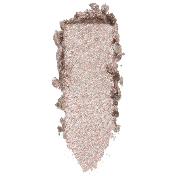 ColourPop I Heart This Super Shock Shadow swatch, a metallic champagne‑taupe with silver glitter, shown as a thick vertical smear with textured, crumbled edges on a white background to highlight its high-shine finish.
