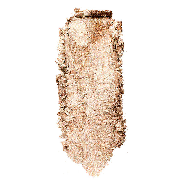 Churro Super Shock Highlighter swatch by ColourPop, streaked vertically to show a warm champagne-gold, luminous metallic sheen with fine shimmer and slightly crumbled texture, set against a clean white background.