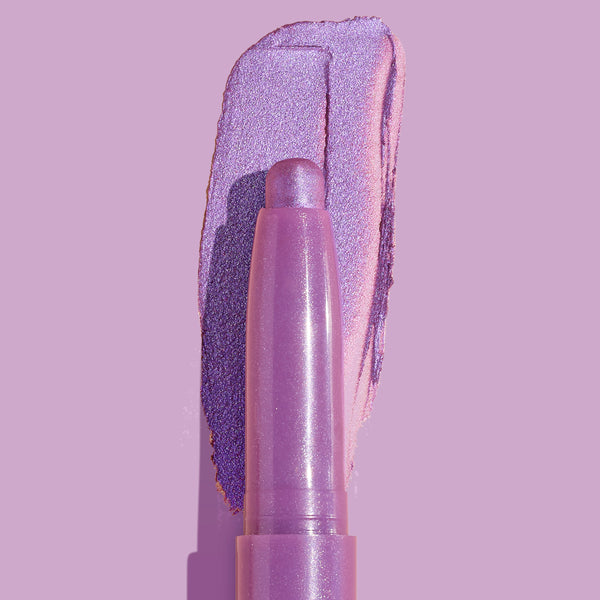 Hey Bestie Shadow Stix lays down a metallic lavender-lilac swatch on a matching purple backdrop, close-up of the creamy twist-up eyeshadow crayon from ColourPop Shadow Stix highlighting its shimmer and smooth texture.