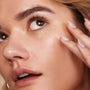 ColourPop Pretty Fresh Creamy Concealer in Light 60 N dotted under the eye and blended with a fingertip, close-up of a model's dewy skin showing smooth, natural coverage.