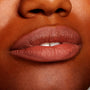 Full lips wearing All My BFFs, a warm rosy-brown nude ColourPop Lippie Pencil, lining and filling the mouth with a creamy satin finish on deep skin in a tight close-up, highlighting precise definition and smooth texture.