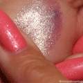 Big Ego ColourPop Jelly Much Shadow swatch shimmering lavender-to-gold duochrome, high-shine metallic payoff on skin, spread in a smooth jelly texture on the back of a hand, shown next to coral glitter nails.