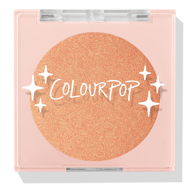 Boombox compact showcasing a closed ColourPop Pressed Powder Highlighter in shade Boombox, a warm peach‑gold shimmer pan set in a pale pink square case with a clear lid, white star accents, and the ColourPop logo.