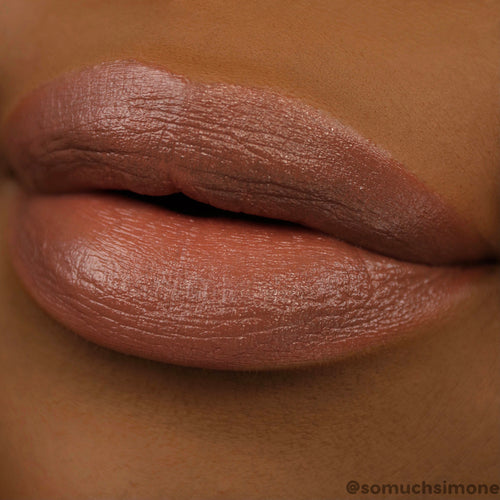 Close-up lips wearing ColourPop Lippie Stix Brat Pack, a creamy satin nude-brown lipstick, showing smooth full-coverage color with a hydrated sheen in a macro swatch on deep skin for shade reference.