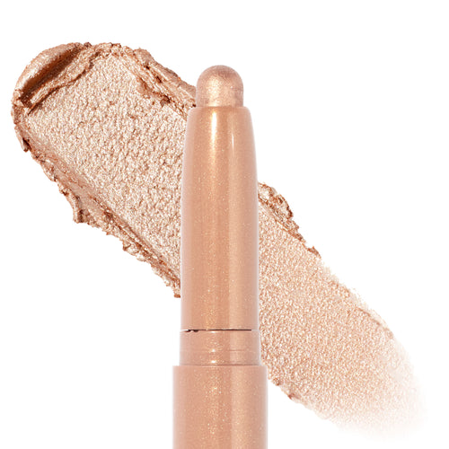 ColourPop Honey BB Shadow Stix, a ColourPop Shadow Stix, glides a metallic champagne-gold eyeshadow swipe behind the rounded cream stick, showing smooth, shimmery payoff and a twist-up crayon design on a clean white studio background.