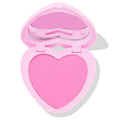 Hot 2 Touch ColourPop Pressed Powder Blush opens to reveal a heart-shaped pan of bright cool-toned pink pressed powder in a pastel pink heart compact with built-in mirror, shown half-open on a white background.
