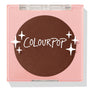 Latte Run ColourPop Pressed Powder Blush sits closed in a square pink compact with a clear lid, revealing a deep latte-brown pan with the ColourPop logo and star graphics, studio shot on a white background.