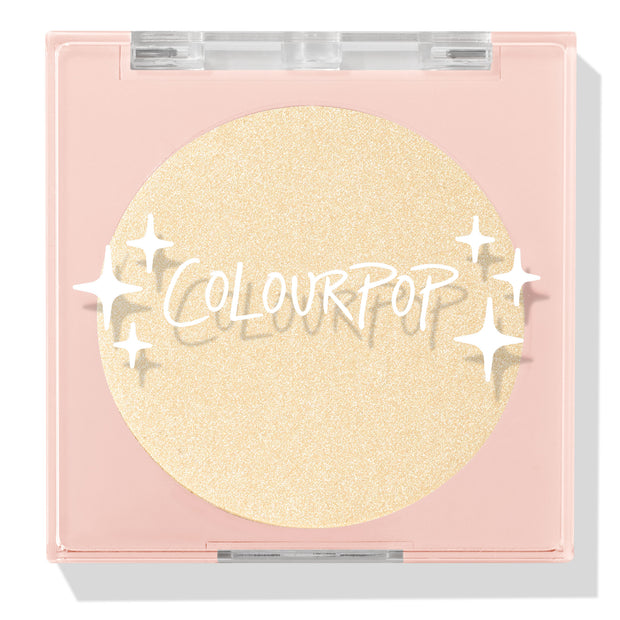 Minted pressed powder highlighter compact showcasing a shimmering champagne-gold pan, closed in a blush-pink square case with clear lid and ColourPop logo and star accents on a white background; ColourPop Pressed Powder Highlighter.