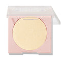 Minted pressed powder highlighter sitting half-open, displaying a large circular pan of pale gold shimmer in a blush-pink compact with a clear lid; ColourPop Pressed Powder Highlighter shade Minted for a luminous glow.