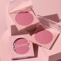 ColourPop New to U pressed powder blush compact opens to reveal a soft rosy‑mauve pan, flanked by a second open compact and a boxed unit, styled on pastel pink blocks; clear lids and star accents brand the ColourPop Pressed Powder Blush.