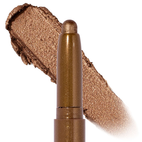Quokka Shadow Stix glides on in a shimmery warm bronze, shown as a twist-up cream eyeshadow crayon with a metallic swatch backdrop, highlighting the smooth, blendable payoff of the ColourPop Shadow Stix.