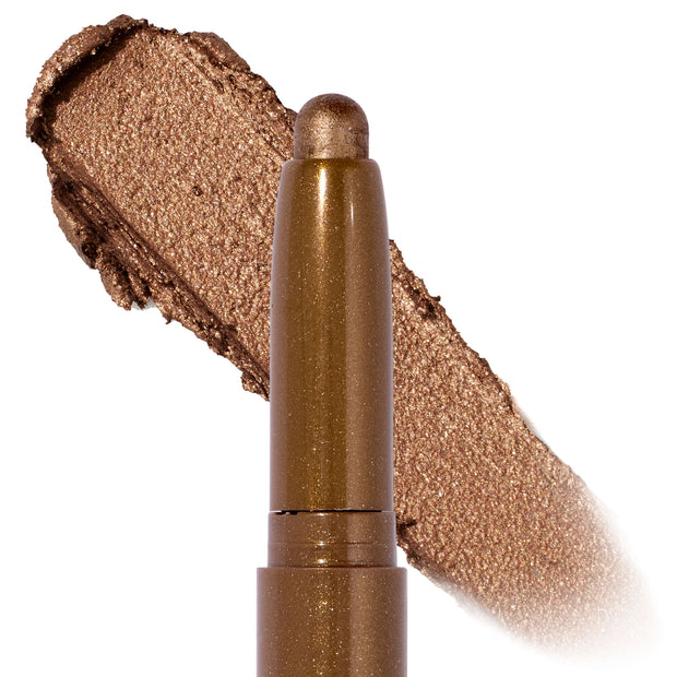 Quokka Shadow Stix glides on in a shimmery warm bronze, shown as a twist-up cream eyeshadow crayon with a metallic swatch backdrop, highlighting the smooth, blendable payoff of the ColourPop Shadow Stix.