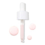 Rose Face Milk dropper dispensing pale pink formula, with three glossy swatches on white, showcasing the lightweight, hydrating texture of ColourPop Face Milk.
