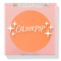 Roxbury Dr ColourPop Pressed Powder Blush compact showing a bright tangerine shade, closed in a pink square case with a clear lid and white star graphics.