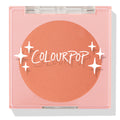 ColourPop Pressed Powder Blush Shortbread shows a warm peach pan sitting in a square pink compact, closed under a clear lid printed with the ColourPop logo and star accents, photographed in clean studio lighting on a white background.