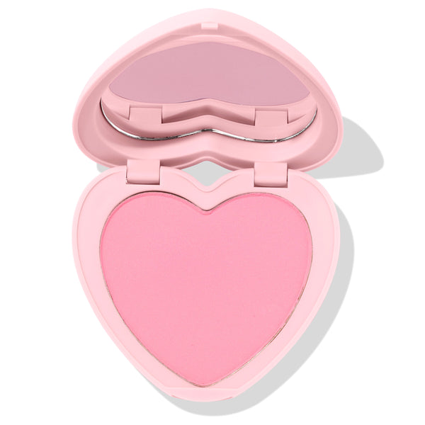 Heart-shaped Sweetheart pressed powder blush sits half open, revealing a soft matte baby-pink pan and built-in mirror in a pastel pink compact; ColourPop Pressed Powder Blush product shot on a clean white background.