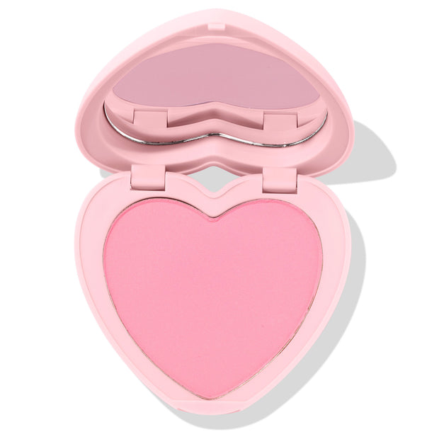 Heart-shaped Sweetheart pressed powder blush sits half open, revealing a soft matte baby-pink pan and built-in mirror in a pastel pink compact; ColourPop Pressed Powder Blush product shot on a clean white background.