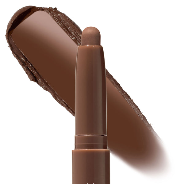 ColourPop Shadow Stix in Walnut Ave stands uncapped, showing a rounded tip while a broad swatch behind reveals a rich warm walnut-brown pigment; creamy, blendable eyeshadow stick on a clean white background.