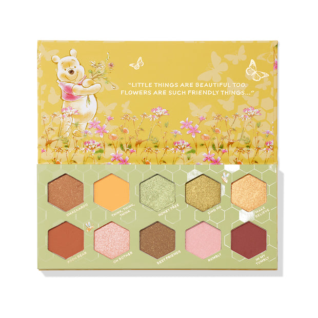 Sweet As Can Bee ColourPop Shadow Palette opens to reveal 10 hex-shaped eyeshadows - warm honey-inspired mattes and shimmers in gold, amber, pink, and green - arranged in a honeycomb inside sage-and-mustard packaging with Winnie the Pooh floral artwork.