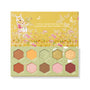 Sweet As Can Bee ColourPop Shadow Palette opens to reveal 10 hex-shaped eyeshadows - warm honey-inspired mattes and shimmers in gold, amber, pink, and green - arranged in a honeycomb inside sage-and-mustard packaging with Winnie the Pooh floral artwork.