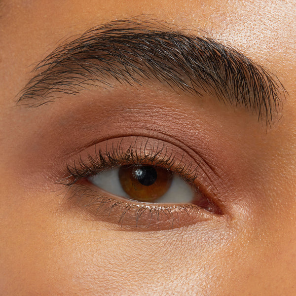 Close-up eye showcases Walnut Ave Shadow Stix, a warm matte walnut-brown shade from ColourPop Shadow Stix, smoothly blended across the eyelid with natural lashes for a soft everyday look.